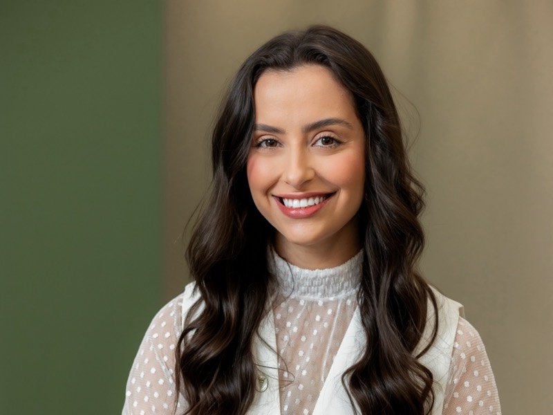 Fisioterapeuta Lorena Araújo sorrindo, de colete branco